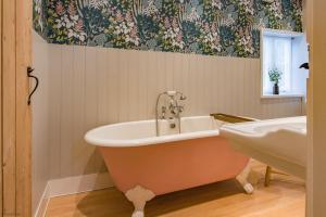 a bath tub and a sink in a bathroom at The Old Post Office by Bloom Stays in Faversham