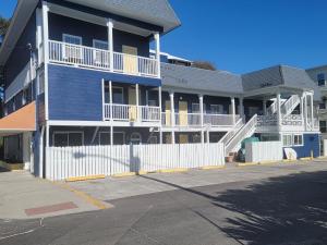 a blue and white building with a white fence at Atlantis Inn - Tybee Island in Tybee Island
