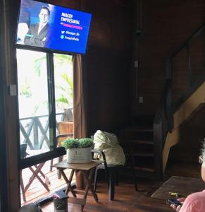 um ecrã de televisão num quarto com uma mesa e uma planta em CASA PARAISO em Puerto Morelos