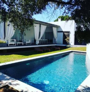 una piscina frente a una casa en VILLA LA PERLA BLANCA, YOUR DREAM IS TRUE en Binibeca