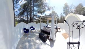 a white room with a bed and some chairs at Wooden Inn - Cabañas Boutique y Bubble Glamping en Creel in Creel