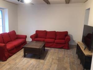 - un salon avec un canapé rouge et une table basse dans l'établissement Bauernhof am Storchennest mit Sauna und E-Tankstelle, à Chrzaszczewo