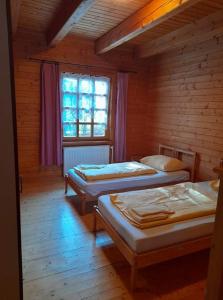 1 dormitorio con 3 camas en una cabaña de madera en Ferienhaus Himmelreich en Seebenstein