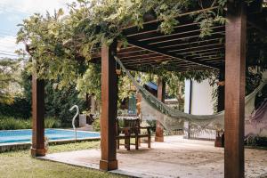 a pergola with a hammock and a swimming pool at Pousada 4 Irmãos in São Bento do Sapucaí