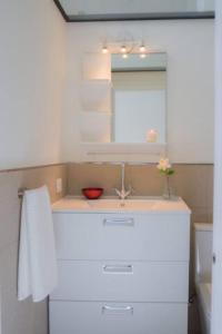 uma cozinha branca com um lavatório e um espelho em APARTAMENTO A ESTRENAR FRENTE A LA PLAZA DE ESPAÑA em Sevilha