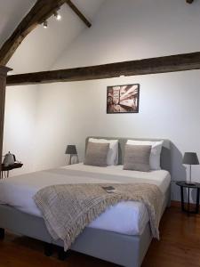 a bedroom with a large bed with white walls at Guesthouse Vakantie Logies Hollywood in Bruges