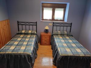 a room with two beds and a table and a window at Casa Jauregui in Ibilcieta