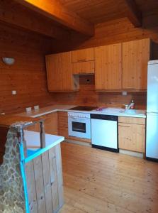 una cocina con electrodomésticos blancos y armarios de madera en Ferienhaus Himmelreich en Seebenstein