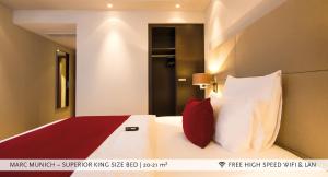 ein Schlafzimmer mit einem großen weißen Bett mit roten Kissen in der Unterkunft Marc München in München
