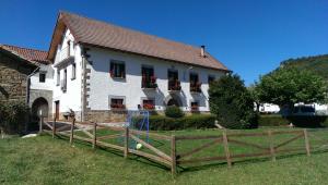 uma casa branca com uma cerca à frente. em Casa Jauregui em Ibilcieta