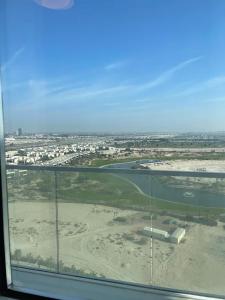 een uitzicht vanuit een raam van een waterlichaam bij Luxury Apartments - DAMAC HILLS in Dubai