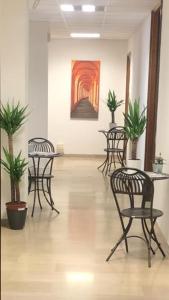 Una habitación con sillas y mesas y un cuadro en la pared. en MyRoom CenterStation Bologna, en Bolonia