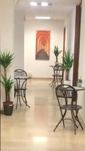 a room with chairs and tables and a painting on the wall at MyRoom CenterStation Bologna in Bologna