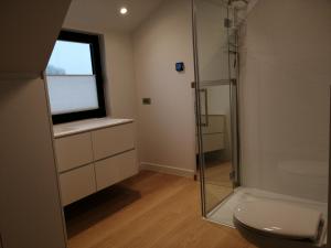 a bathroom with a glass shower and a toilet at Akkerland - incl infra-red sauna - excl option hot swimspa from Spring-Halloween -1 bedroom 1-3 pers - 2 bedrooms 4-6 pers in Zonnebeke
