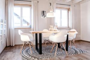 a dining room with a table and chairs on a rug at FLYGGE Apartments in Altusried