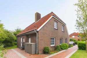 a small brick house with a back yard at Ferienwohnung Watt und Weite in Carolinensiel