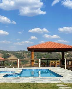 a swimming pool with a gazebo in a yard at Pousada Yvanna in Pirenópolis