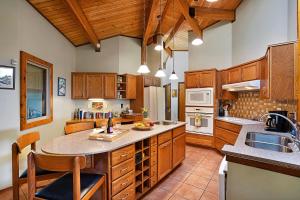 a large kitchen with wooden cabinets and a large island at Hale O' Waikoloa in Waikoloa