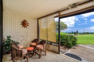 un patio con sillas y una gran puerta corredera de cristal en Waikoloa Village Condos E10, en Waikoloa