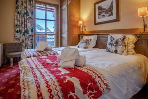 a bedroom with two beds with a wolf pillow on them at Le Refuge du Montagnard, Arc 1950, Skis aux pieds, Spa in Arc 1950