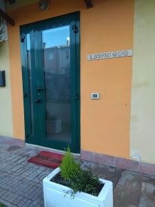 a door to a building with a plant in front of it at Confortevole Appartamento Il Sorriso piano terra ingresso e parcheggio indipendente per una tranquilla privacy in Lugo