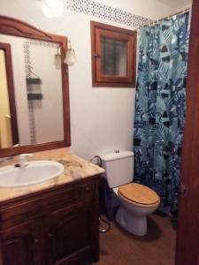 een badkamer met een wastafel, een toilet en een douchegordijn bij Bungalow con vistas a la piscina in Torrevieja