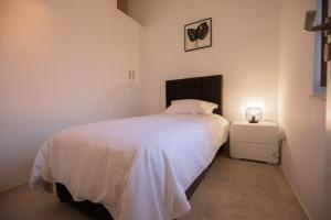 a bedroom with a white bed and a night stand at Arsos Nest in Arsos