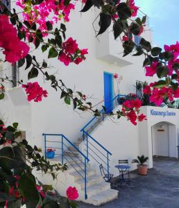 uma escada com flores cor-de-rosa e uma porta azul em Ocean Wings Panoramic SeaView em Kissonerga