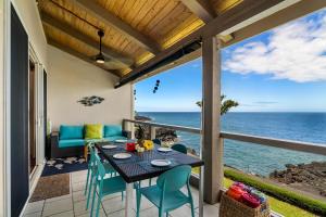 une terrasse avec une table et des chaises et l'océan dans l'établissement Keauhou Kona Surf & Racquet Club #2-303, à Kailua-Kona