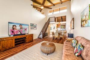 a living room with a couch and a large screen tv at Keauhou Kona Surf & Racquet Club #2-303 in Kailua-Kona