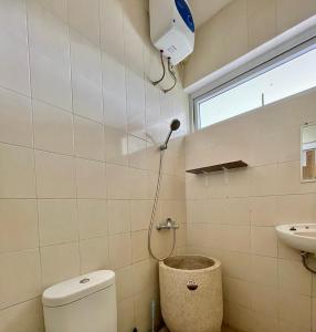 a bathroom with a toilet and a sink and a window at Gerbera 4BR Villa Springhill Garden Malang in Malang +21 photos