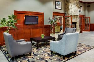 a lobby with two chairs and a tv and a table at Holiday Inn Express & Suites Smithfield - Providence, an IHG Hotel in Smithfield