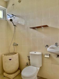 een badkamer met een toilet en een wastafel bij Gerbera 4BR Villa Springhill Garden Malang in Malang