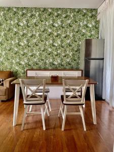 a dining table and two chairs in a living room at Gerbera 4BR Villa Springhill Garden Malang in Malang