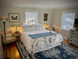 a bedroom with a white bed and a chair at The Homestead in Madison