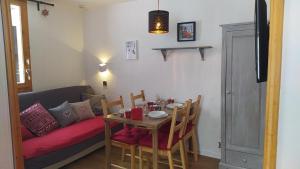 a living room with a table and a couch at PARADISKI-BELLE PLAGNE, Altitude 2050m, APPART skis aux pieds 4 personnes in La Plagne Tarentaise