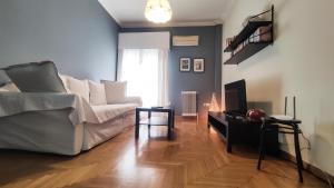 a living room with a white couch and a fireplace at Sandy's apartment in Nafplio