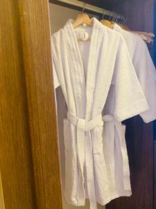 a white robe hanging on a rack in a closet at APARTAESTUDIO AMOBLADO,FURNISHED STUDIO APARTMENT WIFI gratuito in Bogotá