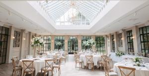 a room filled with tables and chairs with flowers at Woodlands Hotel in Leeds