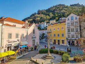 a city street with buildings and a statue in the middle at Sintra Central Flat in Sintra