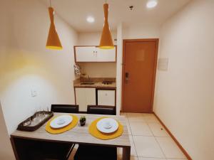 una cocina con una mesa con dos platos. en Suíte completa no centro (SOHO Campos) en Campos dos Goytacazes