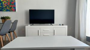 una sala de estar con TV en un armario blanco en Apartamento 1º Línea de Playa - Duna Beach, en Torrox Costa