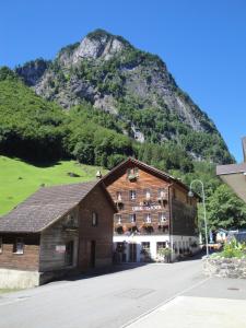 a large building with a mountain in the background at Hotel Urirotstock in Isenthal