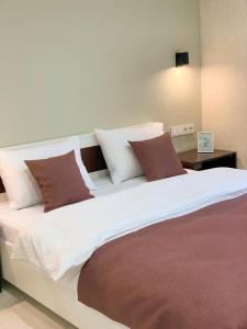 a large bed with brown and white pillows on it at Apart City Home in Mykolaiv