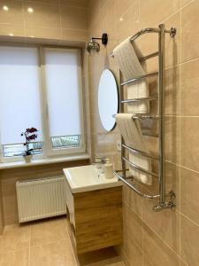 a bathroom with a sink and a shower with a mirror at Apart City Home in Mykolaiv