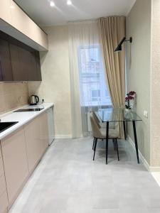 a kitchen with a glass table and a chair at Apart City Home in Mykolaiv