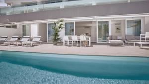 una casa con piscina, sedie e patio di Hotel Baobab Suites ad Adeje