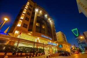 un gran edificio con luces encendidas en una ciudad por la noche en Millennia Olaya Hotel en Riad