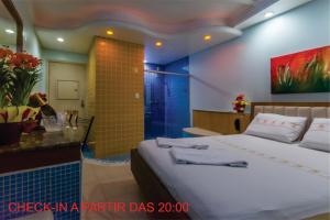 ポルト・アレグレにあるMotel Porto dos Casaisのベッドルーム1室(ベッド1台付)、バスルーム(シャワー付)が備わります。