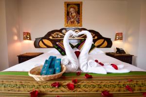 two swans making a heart shape on a bed at Hotel Boutique Gold Garden in Cusco